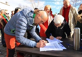 Varios asistentes a la concentración firman el documento en apoyo a las parejas homosexuales.