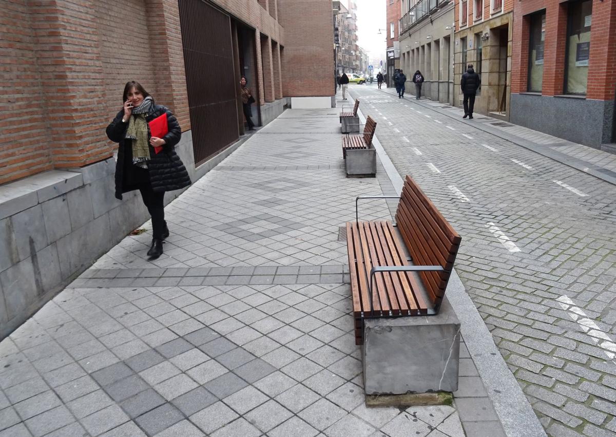 Imagen secundaria 1 - Arriba, cartel y maceteros colocados en el acceso al pasadizo desde la plaza de Federico Watenberg. Debajo, a la izquierda, bancos de madera recién instalados sobre los antiguos bloques de piedra frente al Colegio de Abogados, A la derecha, maceteros frente al bar La Tartana.