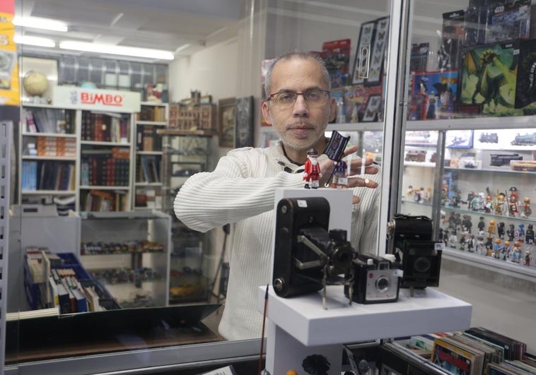 Francisco Javier Rebollo coloca el escaparate su tienda de coleccionismo de la calle Divina Pastora