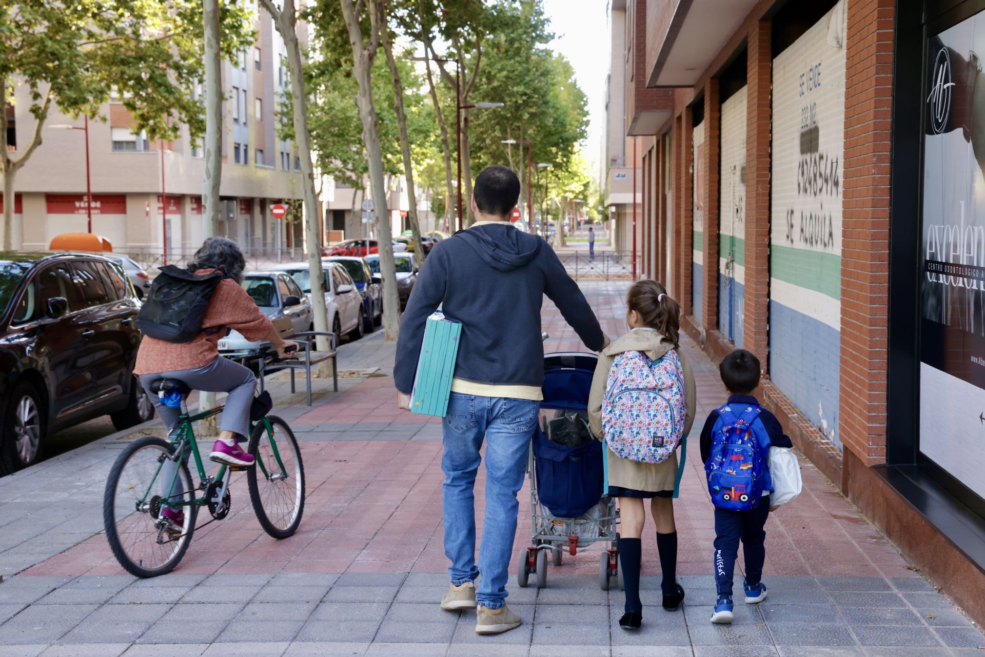 Un padre acompaña a dos menores al colegio en Valladolid.