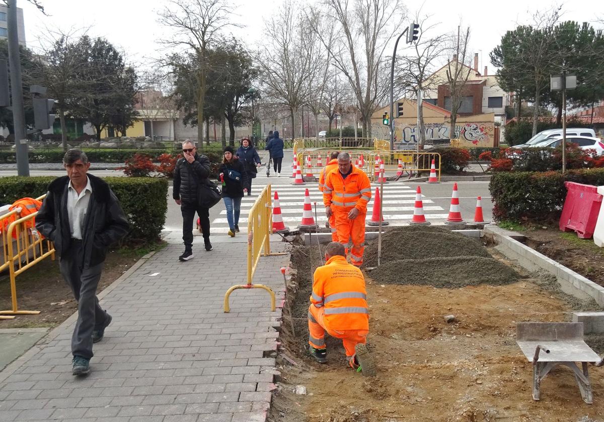 Los peatones pasan en fila india por el estrecho paso habilitado durante las obras de mejora de la accesibilidad del cruce de la avenida de Zamora hacia Vallsur.