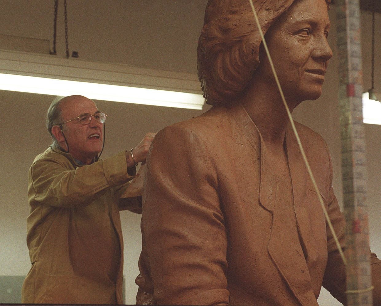 Los López Hernández rematan el busto de la reina en barro. 