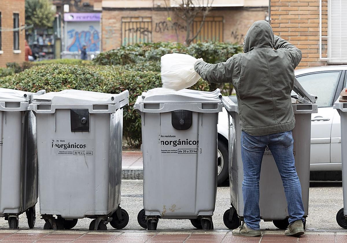 Un hombre echa la basura en un contenedor de la Rondilla.