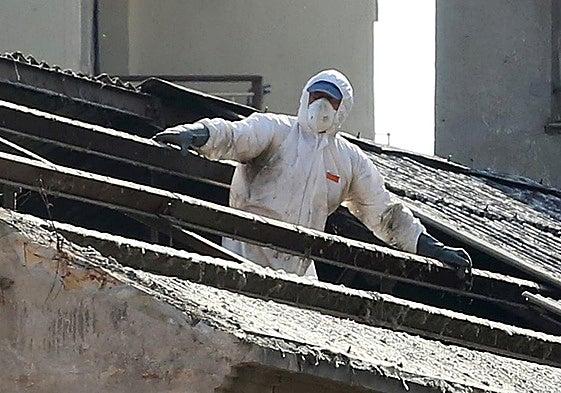 Un trabajador retira amianto de una cubierta en la demolición de un edificio en Segovia.