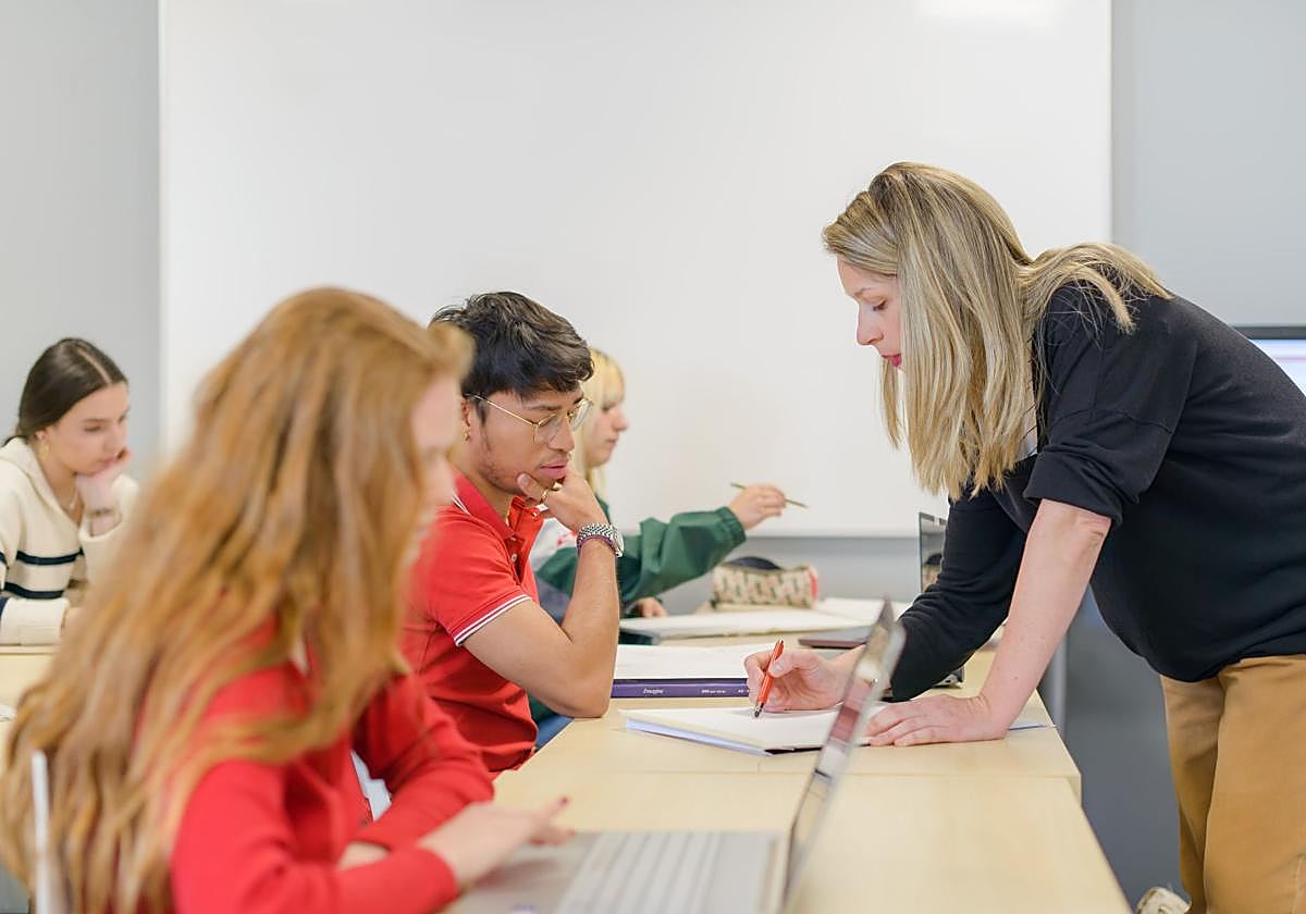 Profesora resolviendo las dudas de un alumno.
