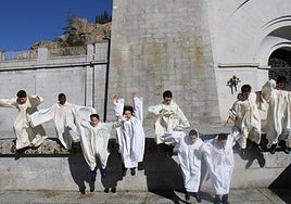 Escolanes de la Escolanía de la Santa Cruz saltan en el patio; debajo, un alumno practica con el violín y otro toca el piano.