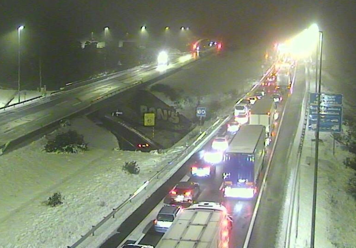 Retención de vehículos en el acceso al túnel de Guadarrama desde la Comunidad de Madrid minutos más tarde de las doce de la noche.