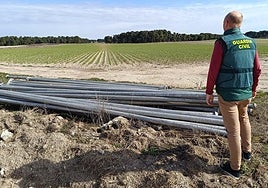 Un agente de la Guardia Civil, junto a los tubos recuperados.