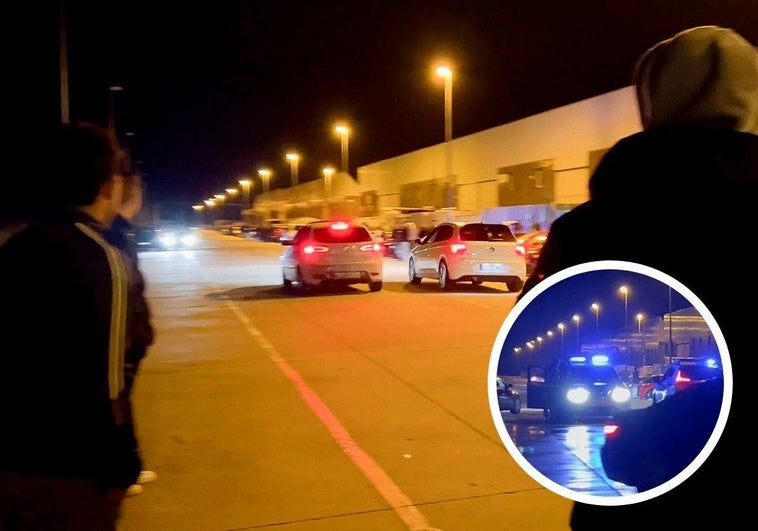 Dos coches frenan tras piscarse, anoche, en el polígono de El Brizo, en Aldeamayor. En el círculo, presencia de la Guardia Civil para disuadir la concentración.