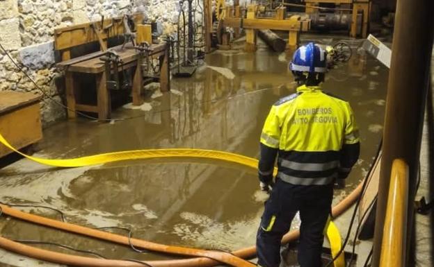 Los bomberos de la ciudad achican agua de la Casa de la Moneda tras la inundación de este sábado.