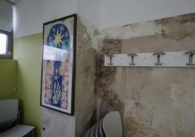 Una de las salas del centro, con humedad en una pared.