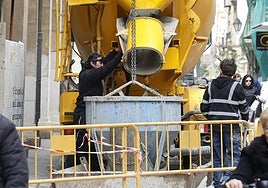 Un camión descarga material en la obra de rehabilitación de un edificio en la Calle Mayor.