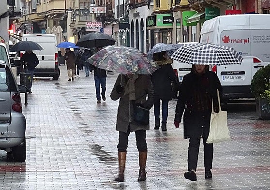 Viandantes se protegen de la lluvia en Valladolid, en una imagen de archivo.