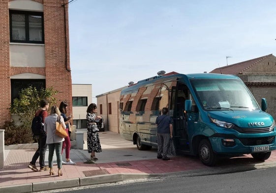 Varias personas suben al autobús en un pueblo de Segovia.