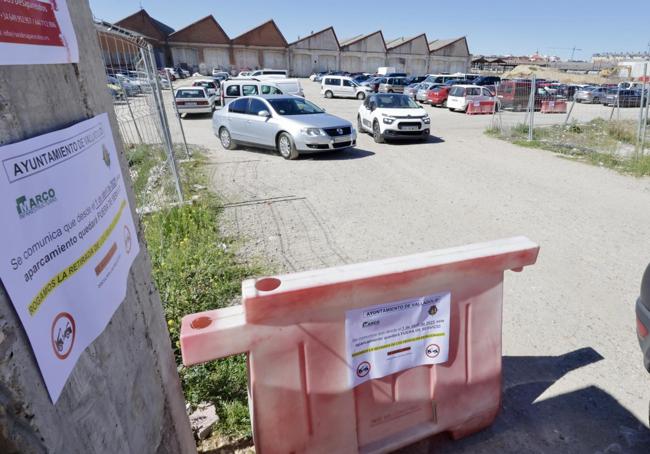 Aparcamiento provisional de la avenida de Segovia y carteles en el acceso que anuncian su cierre este 1 de abril.