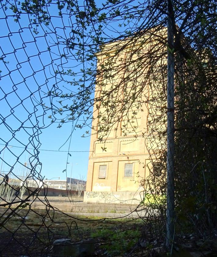 Imagen secundaria 2 - Planta baja del silo de la avenida de Gijón, repleta de gratis, y frecuentada por menores y grafiteros y detalle (debajo a la izquierda) de las ventanas rotas para salir al tejado en su parte superior. A la derecha, boquete abierto en la valla de la parte posterior de la parcela para acceder a su interior.