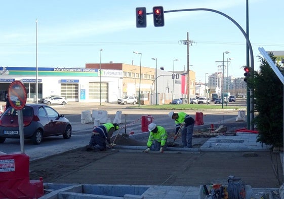 Los operarios trabajan en los remates de la acera de la avenida de El Norte de Castilla, al borde del cruce con Daniel del Olmo.