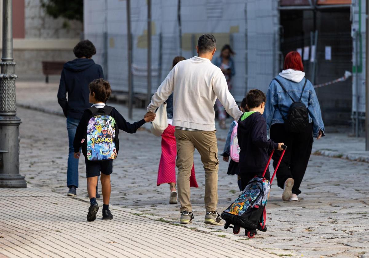 Unos padres llevan a sus hijos al colegio en Valaldolid.