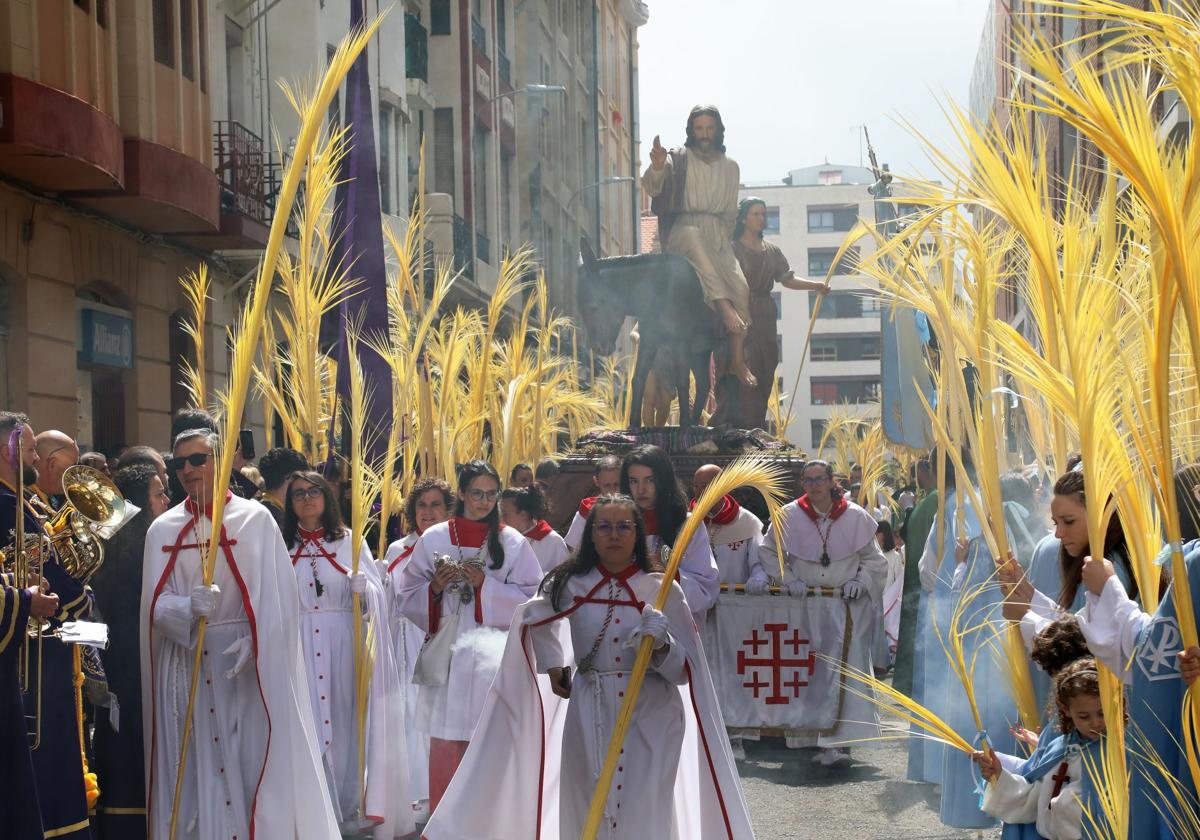 La Borriquilla avanza por la calle Lope de Vega entre el batir de palmas.