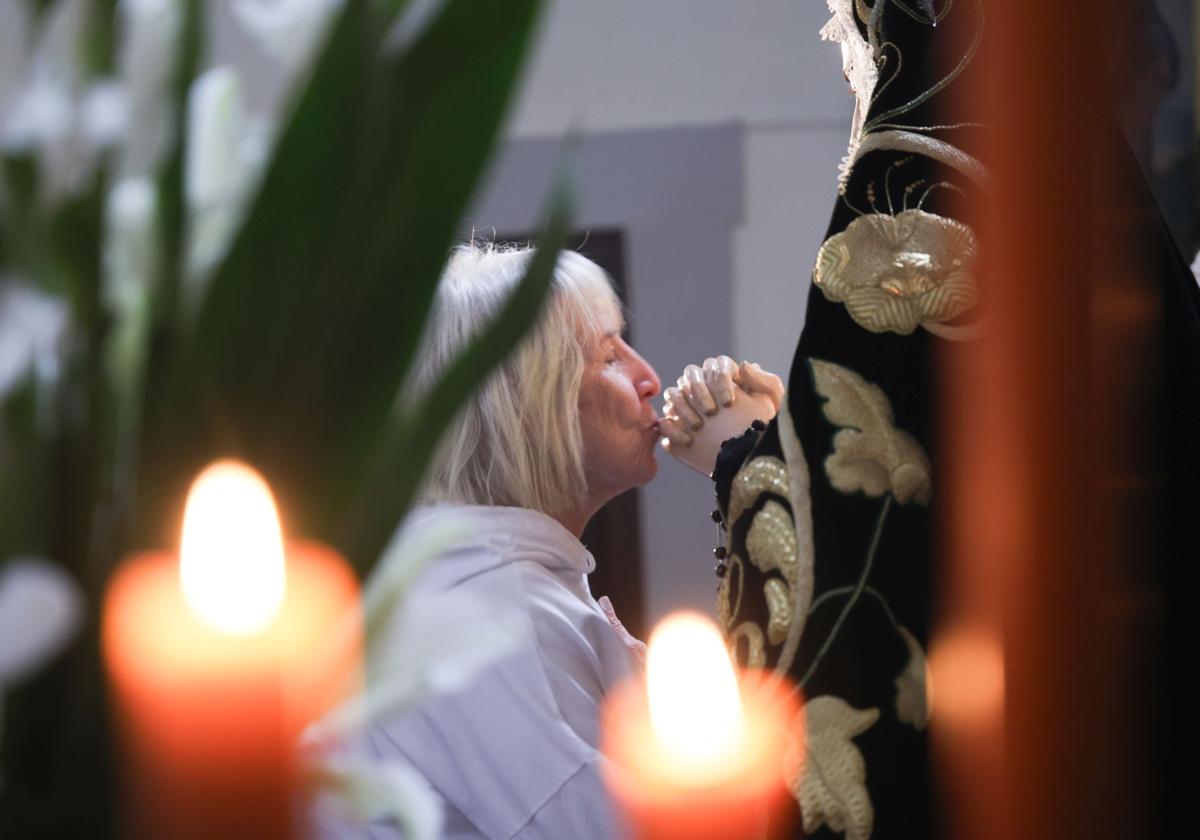 Una mujer besa las manos de Nuestra Señora de la Soledad en el tradicional besamanos celebrado este lunes en Monasterio de Santa Isabel de Hungría