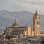 La imponente mole ocre de la Catedral emerge sobre el caserío de la ciudad vieja de Segovia. Al fondo, la sierra de Guadarrama, con la silueta de la Mujer Muerta.