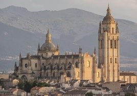 La imponente mole ocre de la Catedral emerge sobre el caserío de la ciudad vieja de Segovia. Al fondo, la sierra de Guadarrama, con la silueta de la Mujer Muerta.