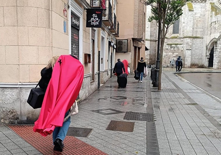 Varios cofrades de la Real y Venerable Cofradía de la Preciosísima Sangre de Ntro. Señor Jesucristo corren a refugiarse en la iglesia de La Antigua para evitar mojar sus hábitos