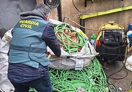 Un agente de la Guardia Civil con parte del cobre recuperado.