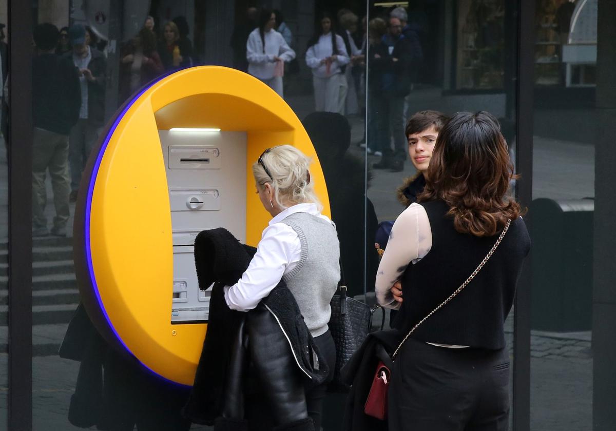 Unos usuarios sacan dinero de un cajero automático.