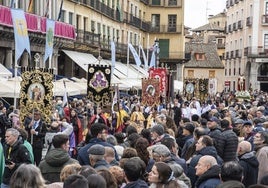 El desfile de estandartes abre el paso, al fondo, del Cristo Resucitado, en su vuelta a la Catedral de Segovia y entre multitud de personas