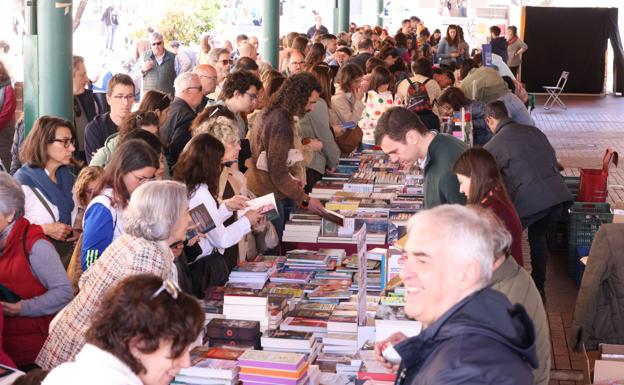 Público arracimado sobre los expositores de los libreros.