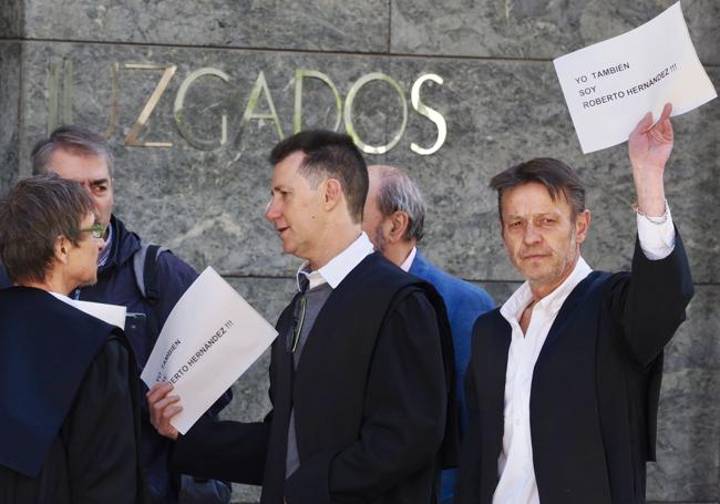 Compañeros de Roberto Hernández muestran carteles a las puertas del juzgado.