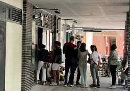 Los clientes de una frutería de Villa de Prado hacen cola a la puerta para adquirir productos durante el apagón.
