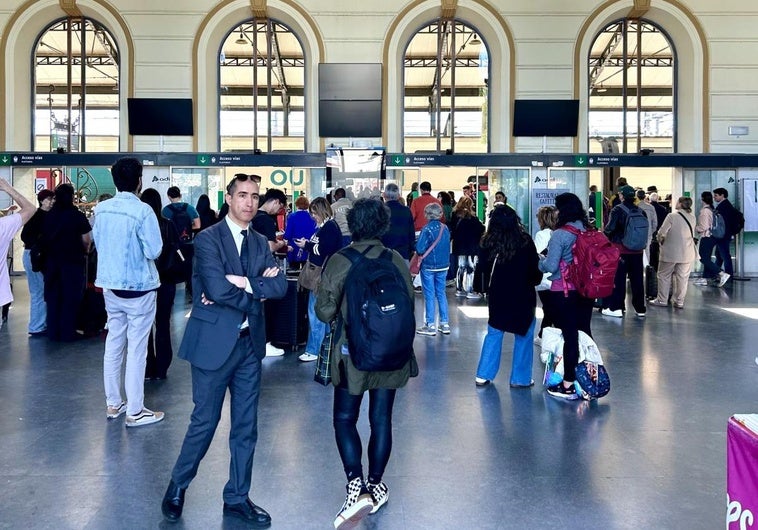 Viajeros en la estación de trenes de Valladolid, con todas las pantallas apagadas.