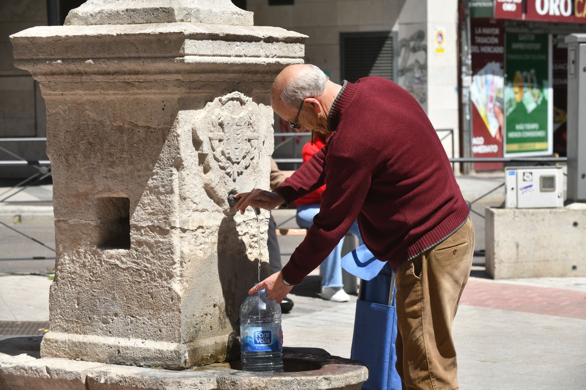 Un vecino rellena una garrafa de agua en la fuente de la plaza de la Cruz Verde.