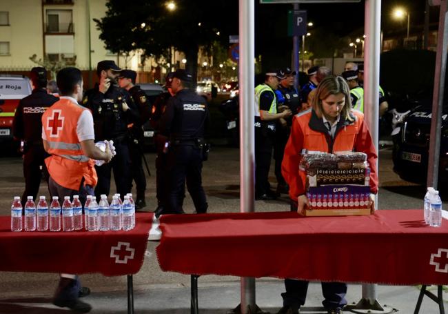 Efectivos de Cruz roja preparan las mesas con bebida y alimentos para los viajeros que se disponían a pasar la noche en la estación de tren de Valladolid.