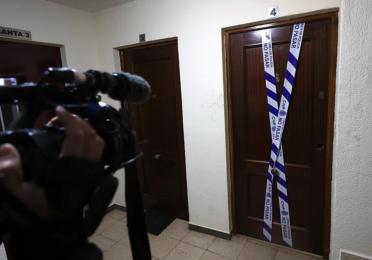 La puerta de la vivienda de Ávila donde fueron halladas muertas dos personas, precintada por la Policía.
