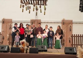 La homenajeada recibiendo un obsequio y un ramo de flores con todos los miembros de su familia.
