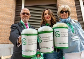 Voluntarios muestran las huchas con donativos de la AECC.