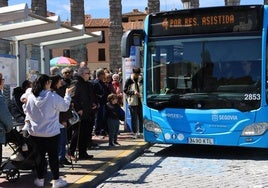Varias personas esperan la llegada del autobús a la parada de la plaza de Artillería.
