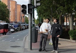 Dos personas se fijan en los semáforos apagados del cruce de la avenida de Palencia con la calle Penitencia.