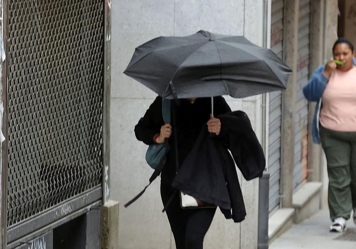 Una mujer se protege de la lluvia en Segovia en una imagen de archivo.