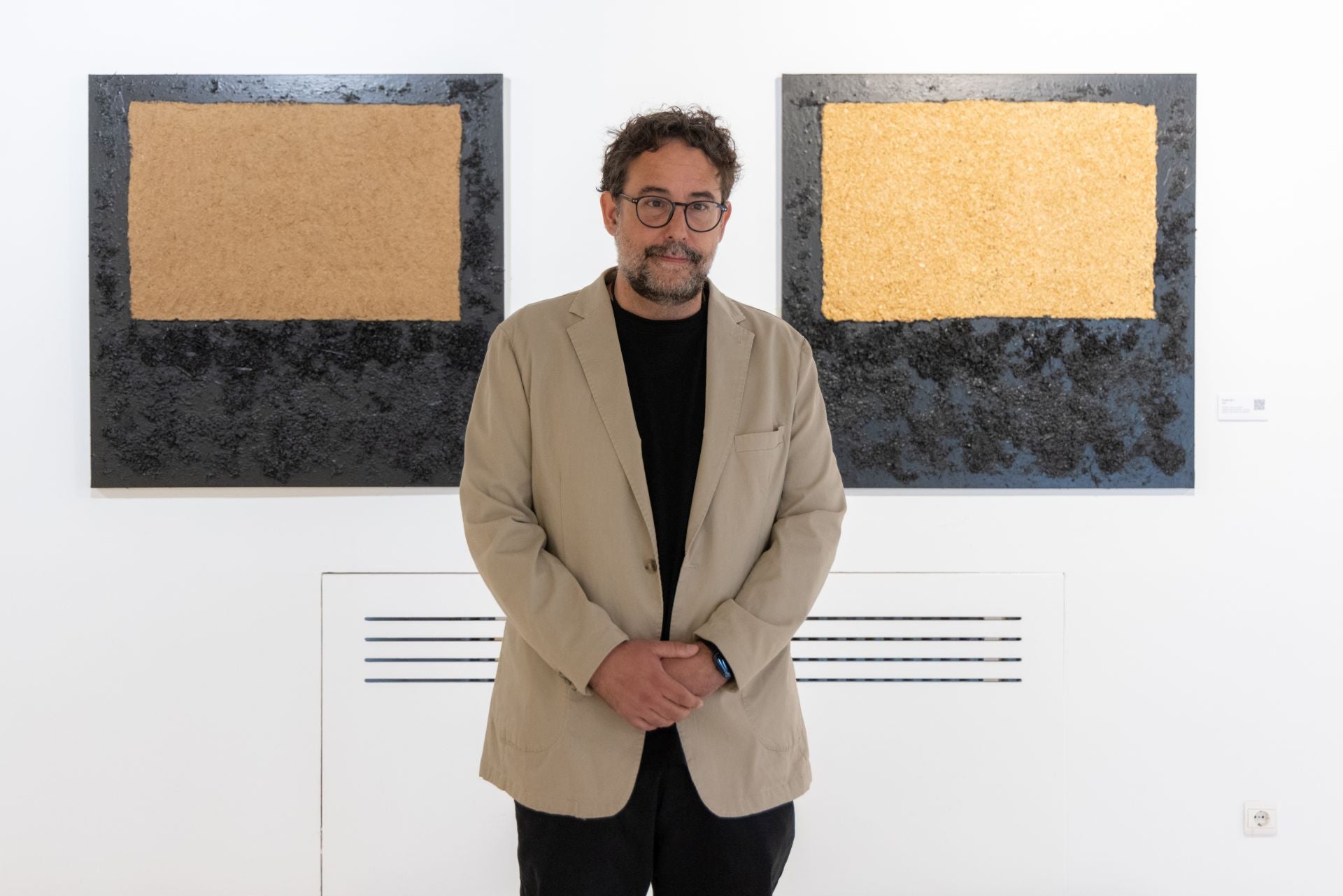 Iván Villapecellín ante dos de sus lienzos.