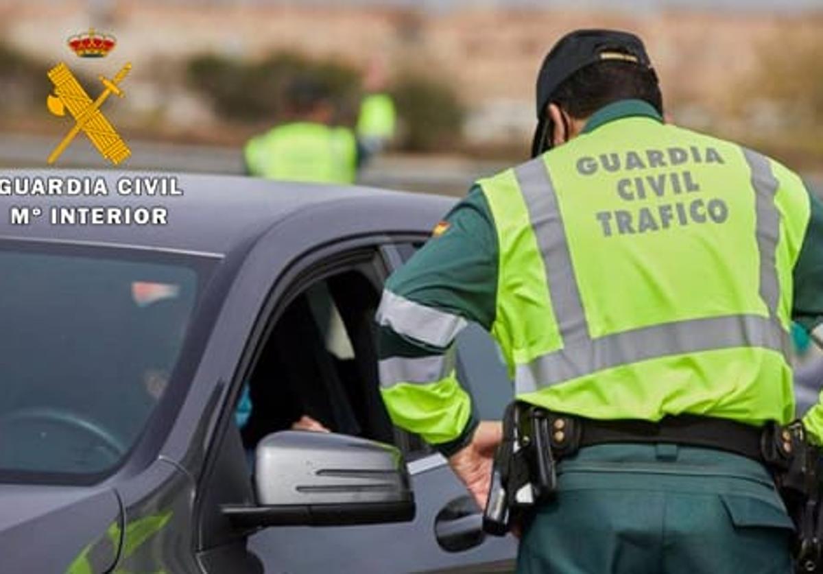 Un agente de la Guardia Civil intercepta un vehículo en un control.