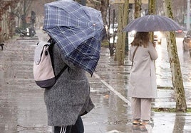 Viandantes se protegen de la lluvia en una imagen de archivo.