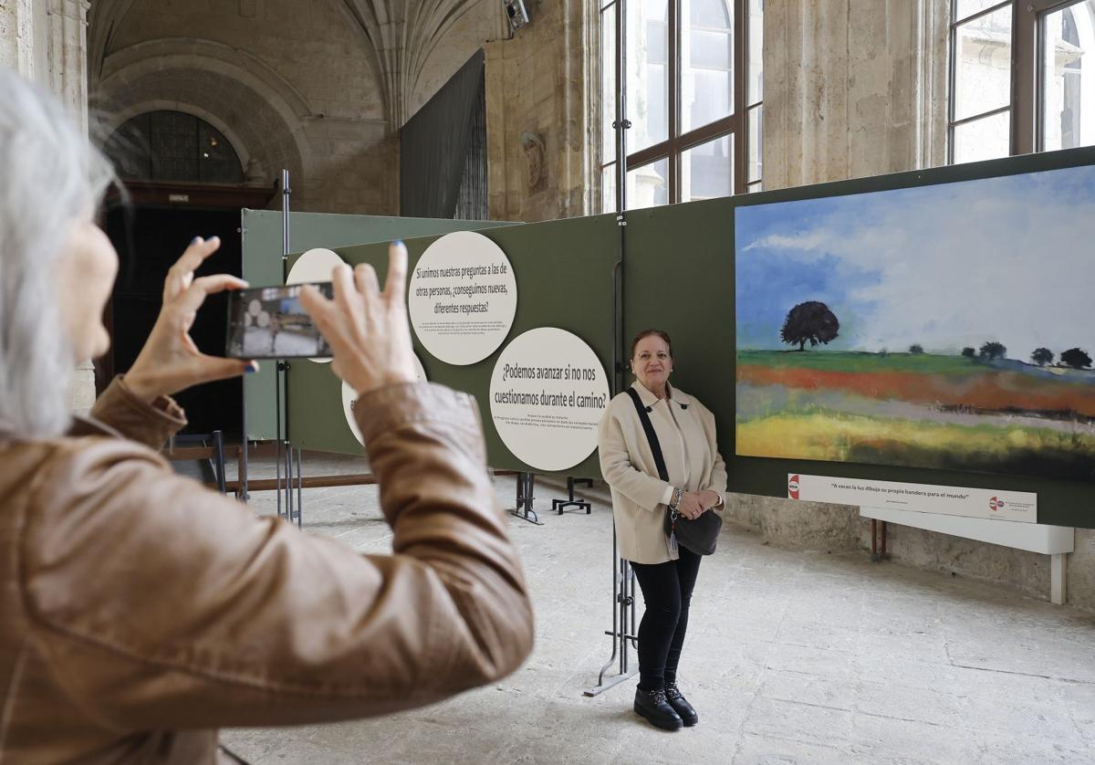 Una mujer toma una foto a Mari Martínez Ramos, autora del cuadro de Pino del Río junto al que posa.