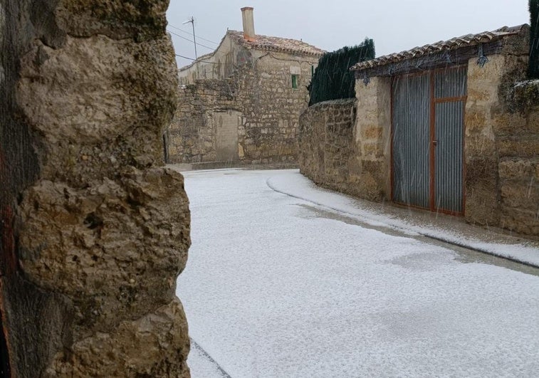 Calle de Palacios del Alcor cubierta de granizo esta tarde.