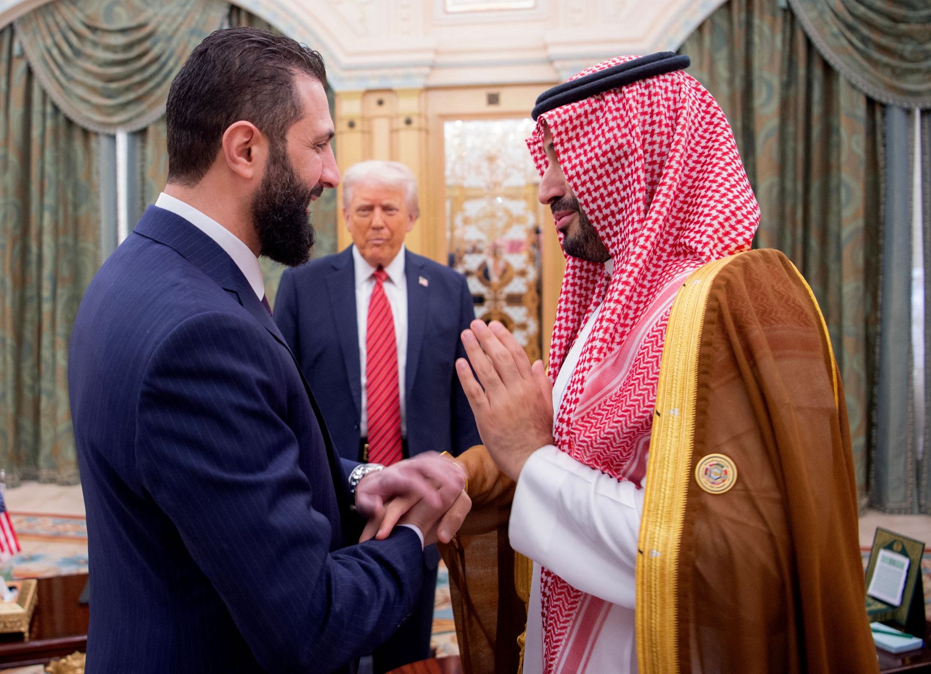 El príncipe heredero saudí, Mohammed bin Salman (der.), saluda al presidente interino de Siria, Ahmed al-Sharaa, ante la mirada del presidente estadounidense, Donald Trump.