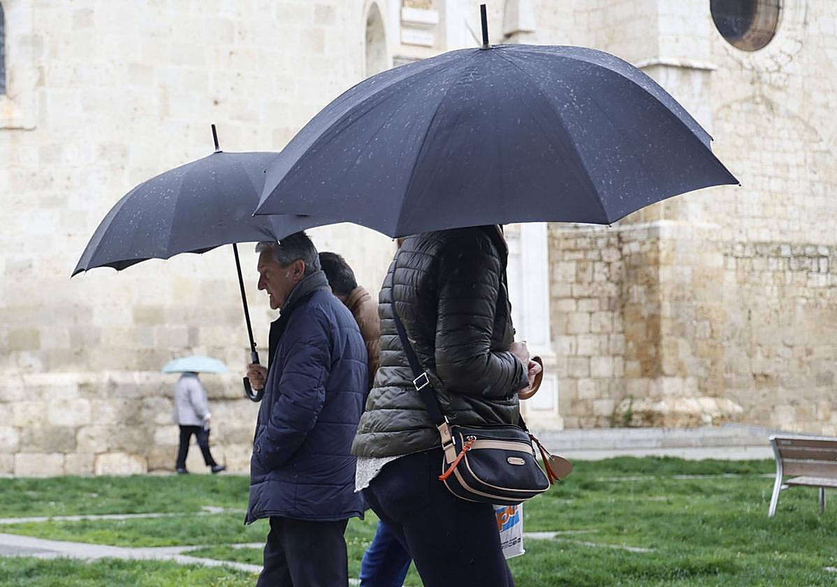 Viandantes se protegen de la lluvia en Palencia, en una imagen de archivo.