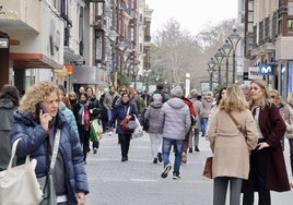 Un grupo de personas camina por la calle Santiago.